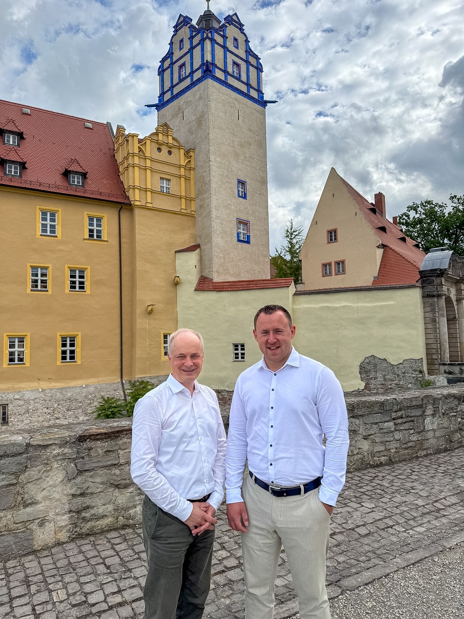 Die beiden Geschäftsführer der Stadtwerke Bernburg GmbH stehen vor dem Schloss Bernburg.